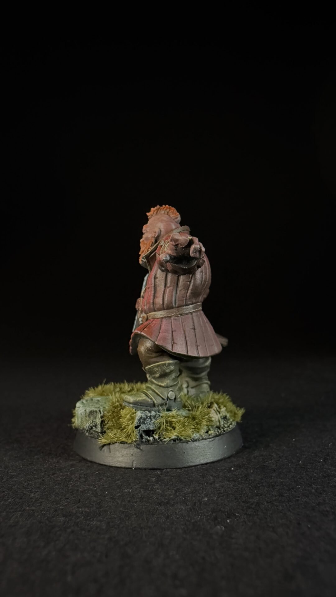 Painted miniature of a medieval knight in pink armor standing on a grassy base, facing forward with a pointed gesture.