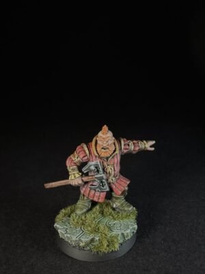 IMG_1499 Dwarf warrior miniature in red armor, gripping a double-headed axe, standing on a grassy rocky base.