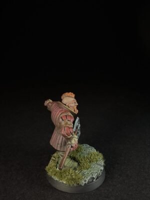 IMG_1502 Tabletop miniature of a red-armored knight, holding a weapon, standing on a grassy, mossy base.