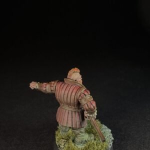 Back view of a medieval knight miniature in red-brown plate armor, standing on a grassy base with a sword sheathed at the side.