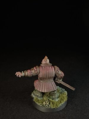 IMG_1504 Rear view of a pink-armored medieval knight miniature, holding a sword, standing on a grassy base.