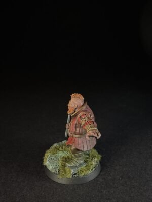 IMG_1506 Miniature bearded warrior in red armor standing on a mossy base against a black background.