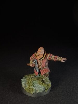IMG_1507 Fantasy dwarf miniature in red armor, wielding a war hammer with an outstretched left arm, standing on a grassy stone base.