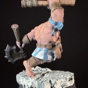 Miniature fantasy barbarian figure mid-stride, wielding a large double-headed axe and a wooden club, wearing a blue-striped kilt and tan armor, standing on a rocky base.