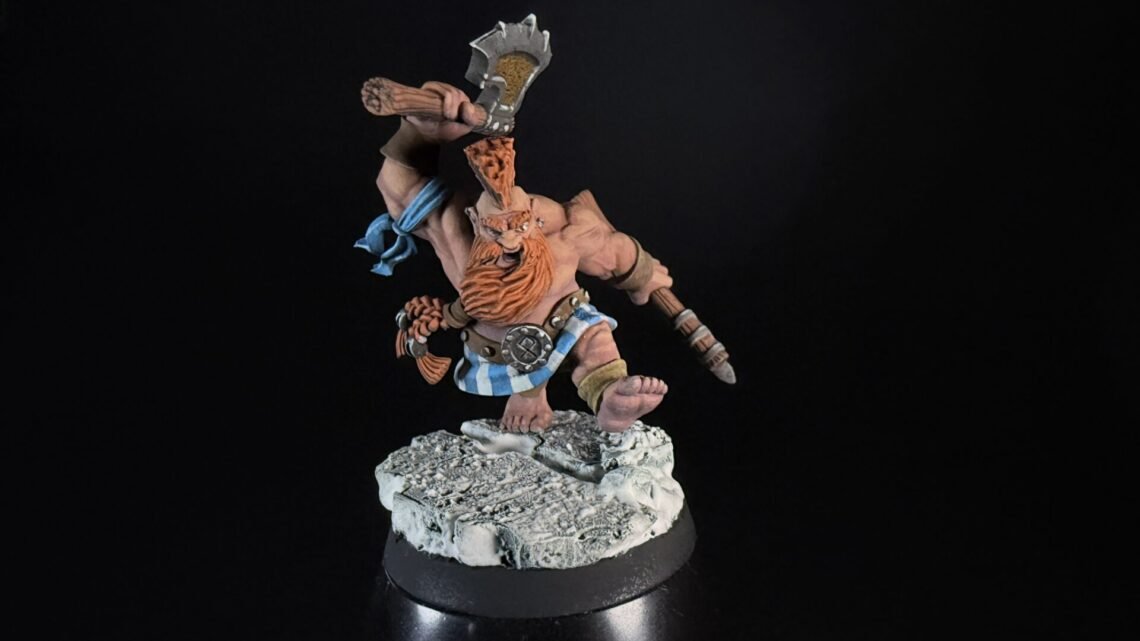 Painted dwarf barbarian miniature raising a battle-axe on a rocky base against a black background.