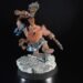 Painted dwarf barbarian miniature raising a battle-axe on a rocky base against a black background.
