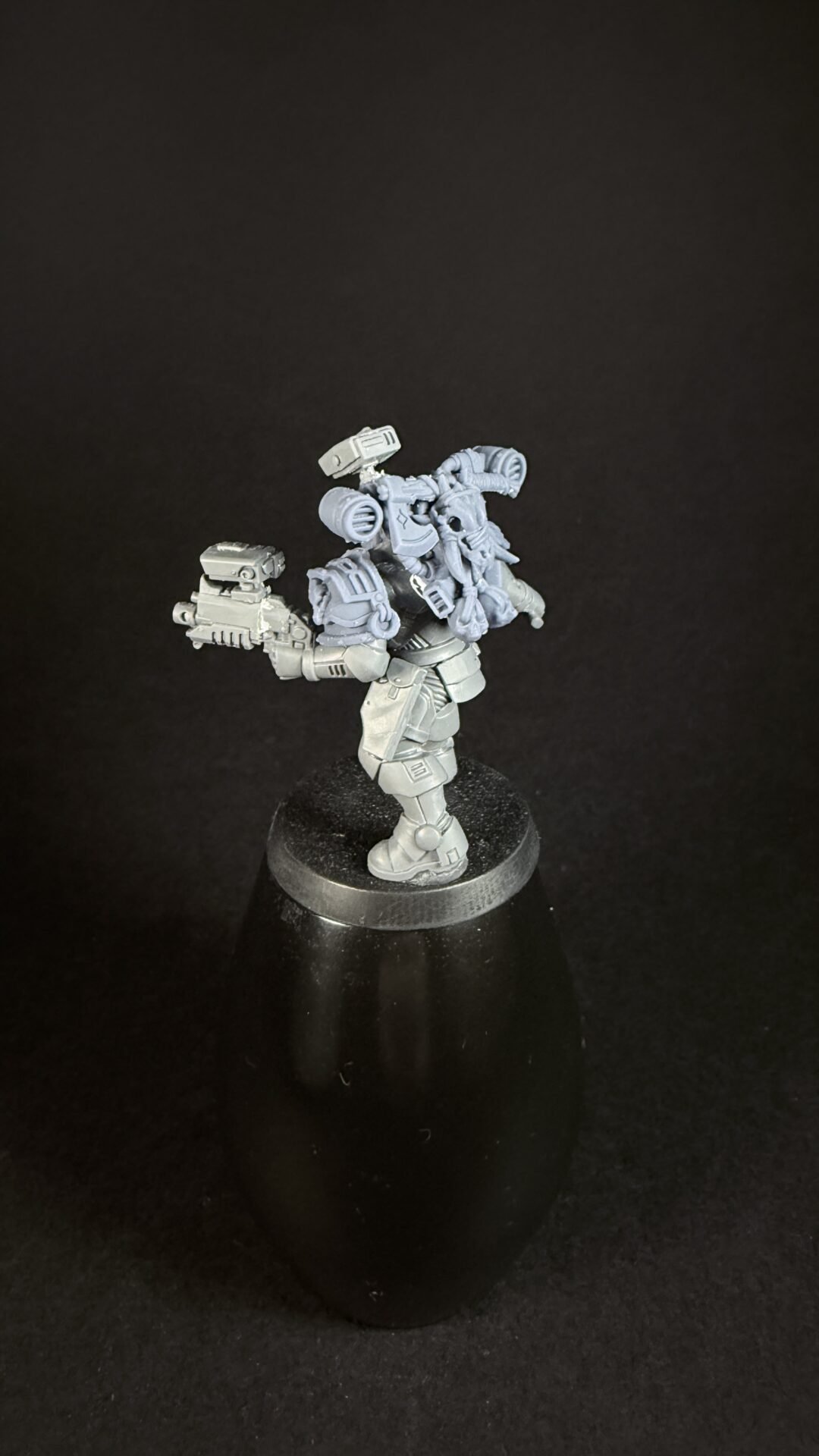 Sci-fi armored miniature figure holding a large gun, mounted on a black display base