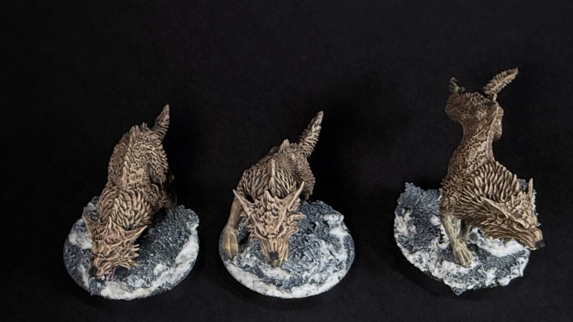 Three brown dragon sculptures perched on rugged grey rocks against a black background, viewed from the side.