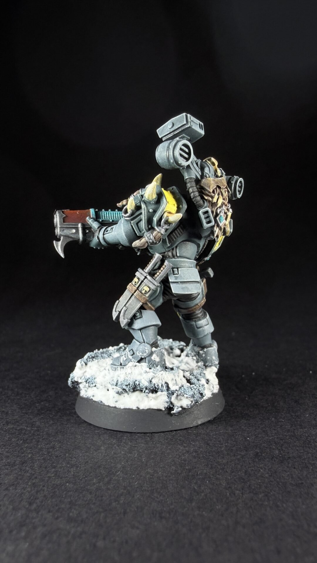 Heavily armored orc-inspired sci-fi miniature firing a large gun on a snow-dusted base.