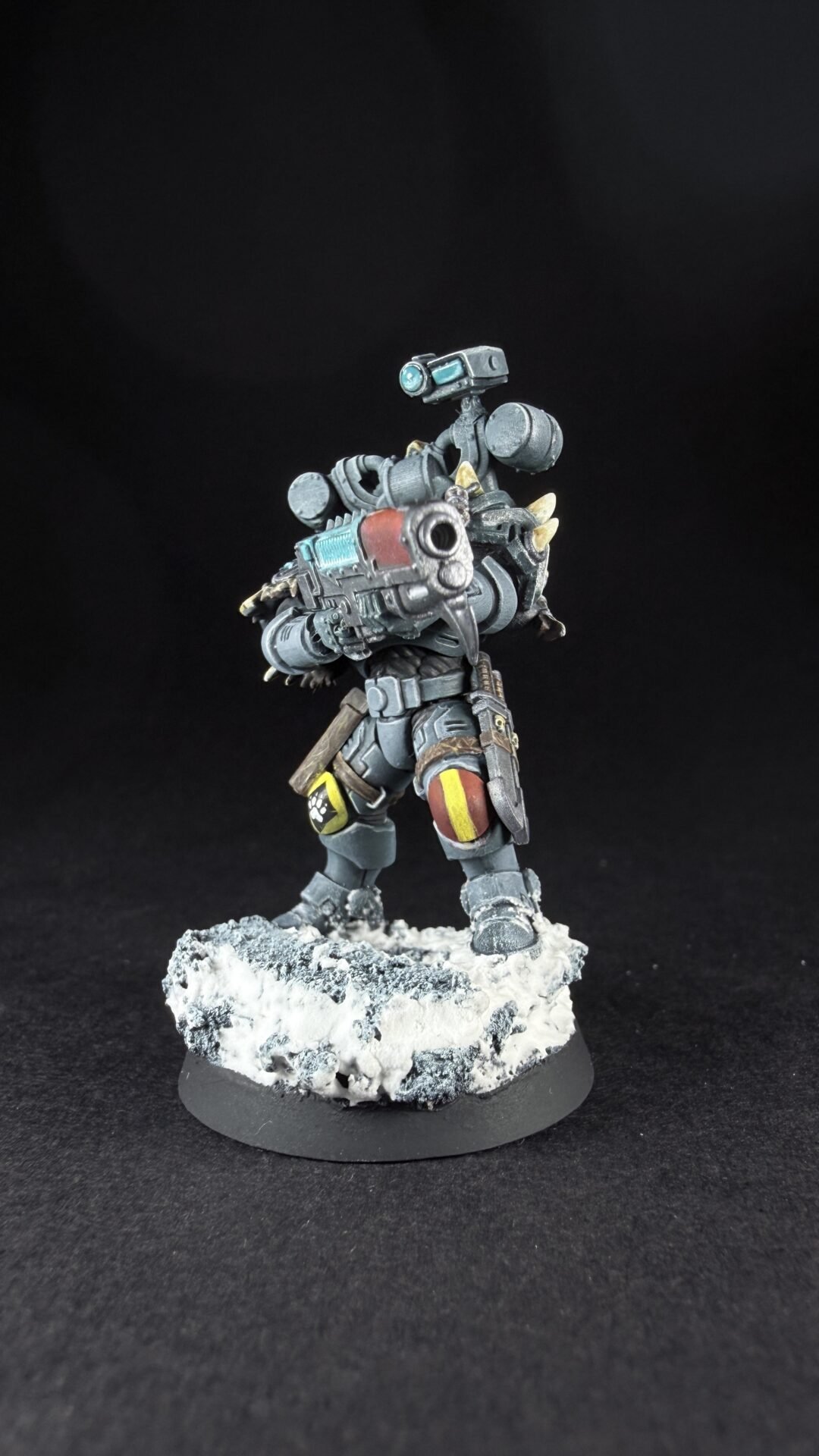 Armored sci-fi trooper miniature aiming a large gun, with teal highlights, standing on a snowy rocky base.